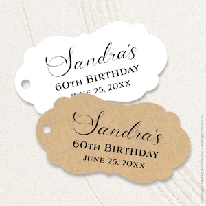 May include: Two decorative tags with scalloped edges. One is white, the other is tan. Both tags have the text "Sandra's 60th Birthday June 25, 20XX" in black script. Each tag has a small hole for attaching.