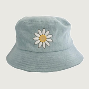 May include: A light blue denim bucket hat with a white daisy embroidered on the front.