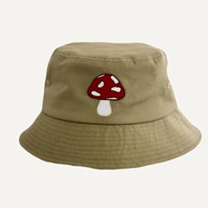 May include: A khaki bucket hat with a red and white mushroom embroidered on the front.