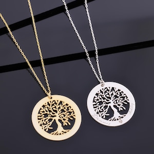 May include: Two necklaces with tree of life pendants. One is gold-toned, the other silver-toned. The pendants are circular with a tree design cut out. The silver necklace has names engraved on it.