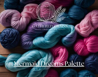 May include: A collection of yarn skeins in various shades of blue, pink, and purple. The yarn is arranged in a circular pattern, with the skeins overlapping each other. The yarn is labelled "Mermaid Dreams Palette" and "Gathered Grains Crochet Co."