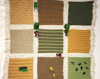 May include: A crocheted baby blanket with a farm theme. The blanket is made of different colored squares, each representing a different part of a farm. There are toy tractors and other farm vehicles on the blanket.