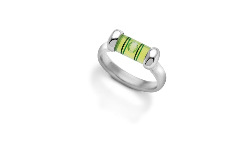 Pu&ograve; includere: Un anello d'argento con una bolla di livello verde e gialla incorporata nella fascia.