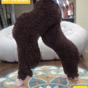 May include: Dark brown fuzzy trousers with a textured, shaggy appearance. The trousers are labelled size XL. A yellow text box on the image states: Tails, fur, and accessories NOT included! The trousers feature a high-waisted fit and reach the ankles.