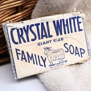May include: A rectangular bar of Crystal White Family Soap in a vintage off-white paper wrapper with blue text and a graphic of a sheep. The packaging features the words Giant Size and Peet's, with a thin string wrapped around the center.