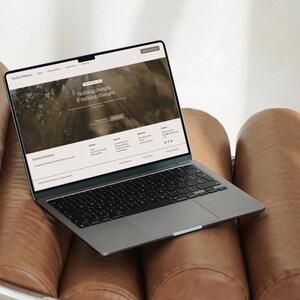 Puede incluir: Un port&aacute;til gris oscuro con teclado negro y una pantalla que muestra un sitio web titulado Kindred Wellness. La p&aacute;gina web presenta el texto Nothing changes, if nothing changes, junto con men&uacute;s de navegaci&oacute;n e iconos sociales.