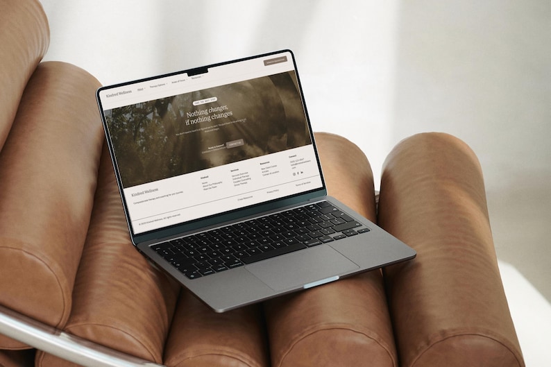 Puede incluir: Un port&aacute;til gris oscuro con teclado negro y una pantalla que muestra un sitio web titulado Kindred Wellness. La p&aacute;gina web presenta el texto Nothing changes, if nothing changes, junto con men&uacute;s de navegaci&oacute;n e iconos sociales.