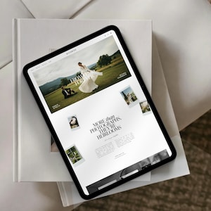 Puede incluir: Una tableta negra muestra un sitio web de fotograf&iacute;a de bodas. El sitio presenta im&aacute;genes de una novia y un novio, con el texto &laquo;FROM FOREVER FOR A DAY&raquo;. La tableta descansa sobre un libro blanco.