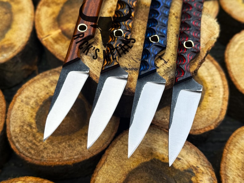 May include: Close-up of four custom knives with various handle designs and polished blades. The handles feature wood grain and patterned resin in shades of brown, blue, and red. The blades are silver and the knives are arranged on wooden slices. The text "Rick's Metals" is visible.