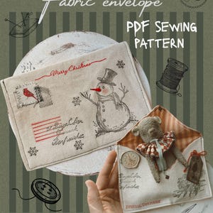 May include: A beige fabric envelope PDF sewing pattern featuring a snowman, a red cardinal, and Merry Christmas text. A second open envelope contains a small teddy bear with a ruffled collar, a clock motif, and Special Delivery text.