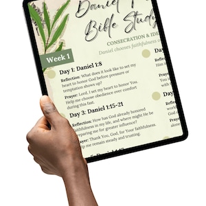 May include: A digital tablet displaying a Bible study guide titled "Daniel Fast Bible Study." The screen shows text about consecration and faithfulness, with a "Week 1" section and daily reflections and prayers. The tablet is held by a hand.