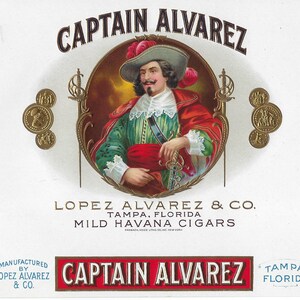 May include: Vintage cigar box label featuring a portrait of Captain Alvarez in a green and red outfit, a hat, and a sword. The label includes the text "CAPTAIN ALVAREZ" and "LOPEZ ALVAREZ & CO. TAMPA, FLORIDA MILD HAVANA CIGARS."