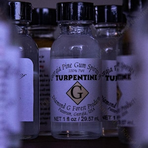 Puede incluir: Botellas de vidrio transparente con tapas negras, etiquetadas como "Turpentine". Las etiquetas dicen "Georgia Pine Gum Spirits" y "Diamond G Forest Products". Cada botella contiene 29,57 ml de producto.