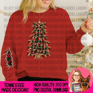 Puede incluir: Una sudadera roja de manga larga con un gráfico central de un árbol de Navidad hecho de tela de cuadros verde, roja y blanca con bordes deshilachados y un lazo en la parte superior. Un parche de cuadros a juego es visible en la manga izquierda.