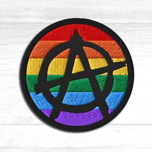 Puede incluir: Parche bordado circular con un símbolo de anarquía negro sobre un fondo de arcoíris. El parche tiene un borde negro. Los colores del arcoíris incluyen rojo, naranja, amarillo, verde, azul y morado.