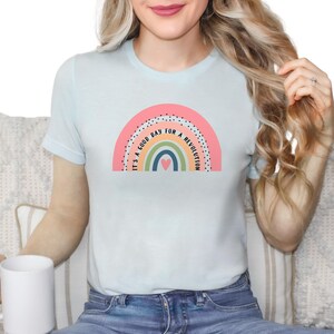 May include: A light blue t-shirt with a rainbow graphic and the text "It's a good day for a revolution".