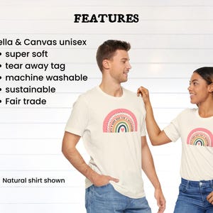 May include: Two white t-shirts featuring a rainbow graphic and the text "It's okay to not be okay". The shirts are made from Bella + Canvas unisex fabric. Features include super soft, tear away tag, machine washable, sustainable, and fair trade.