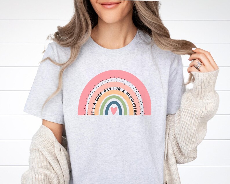 May include: A light grey t-shirt with a rainbow graphic and the text "It's a good day for a revolution".
