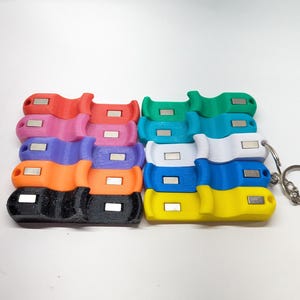 May include: A set of 10 colorful keychains with a bottle opener and a magnet. The keychains are in various colors, including red, pink, purple, orange, black, green, blue, white, and yellow.