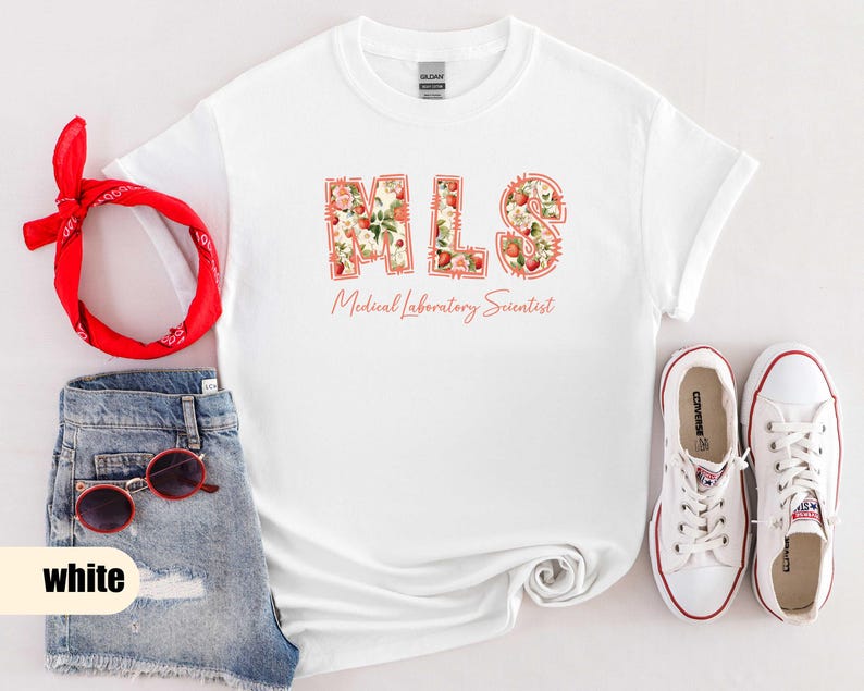 Puede incluir: Camiseta blanca con las letras "MLS" en un dise&ntilde;o floral, con las palabras "Medical Laboratory Scientist" debajo. La imagen tambi&eacute;n incluye pantalones cortos de mezclilla, gafas de sol rojas, una bandana roja y zapatillas blancas.