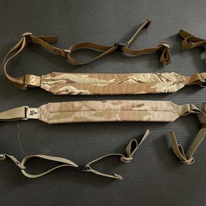 Puede incluir: Dos correas ajustables con estampado de camuflaje con correas y hebillas marrones. Las correas están hechas de un material suave y duradero y son perfectas para llevar una variedad de artículos.