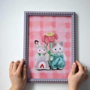 Peut inclure: Tableau encadr&eacute; repr&eacute;sentant un lapin et un chat, sur fond rose &agrave; carreaux. Le lapin porte du rose, le chat du bleu. Le cadre est violet clair. L'&oelig;uvre a un style fantaisiste et illustratif.