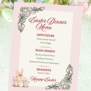 Peut inclure: Un menu de dîner de Pâques rose avec des coins floraux et une illustration de lapin à l'aquarelle. Le menu énumère les entrées, les plats principaux et les desserts, y compris le jambon glacé au miel et le gâteau aux carottes. Le texte "Joyeuses Pâques" est en bas.