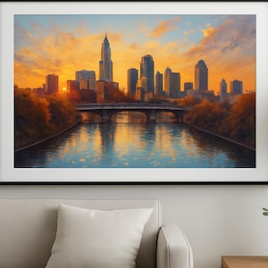 Könnte beinhalten: Gerahmter Kunstdruck einer Stadtlandschaft bei Sonnenuntergang. Das Bild zeigt einen Fluss mit einer Brücke, die zu einer Skyline aus hohen Gebäuden führt. Der Himmel ist eine Mischung aus Orange, Gelb und Blau, die sich im Wasser spiegeln.