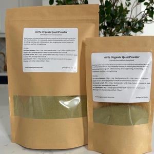 Peut inclure: Deux sachets en papier kraft avec des fenêtres en plastique transparent montrant de la poudre verte à l'intérieur. Les sachets sont étiquetés "100% Poudre de Qasil Biologique" et contiennent un produit naturel pour la peau fabriqué à partir des feuilles séchées de l'arbre Gob d'Afrique de l'Est. Les sachets sont d'origine éthique de Somaliland.