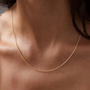 Puede incluir: Un delicado collar de cadena de oro, perfecto para superponer o llevar solo.