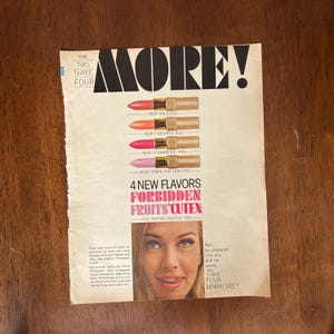 May include: A vintage magazine advert for Cutex lipsticks, showcasing four new flavours: Kola Kiss, Pineapple Kiss, Strawberry Kiss, and Grape Yum Yum Kiss. The ad features the word "MORE!" and a woman with lipstick.