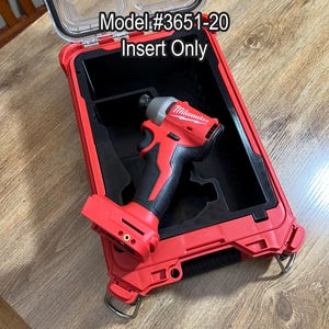 May include: A red and black power tool sits inside a red case with a clear lid. The text "Model #3651-20 Insert Only" is visible on the case. The tool is a cordless impact driver.