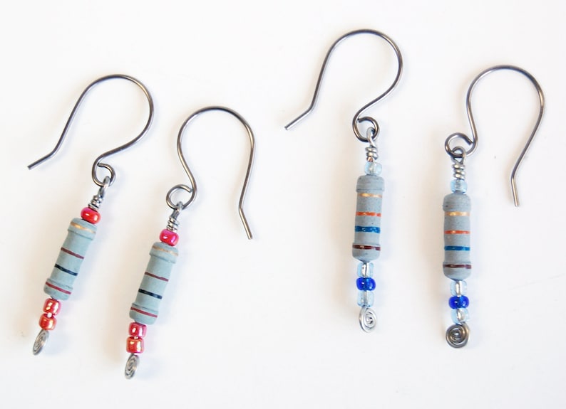 May include: A pair of earrings with gray ceramic resistor beads and colorful beads. The earrings have silver hooks.