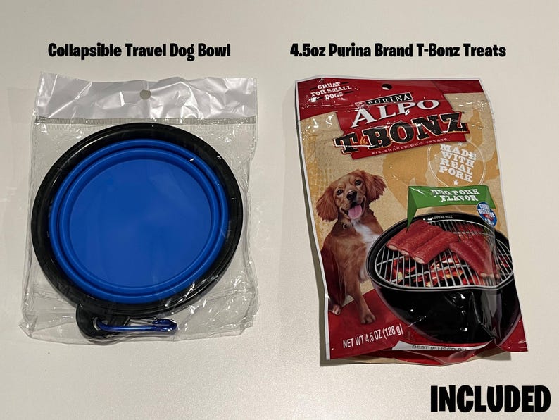 Op de afbeelding: Een blauwe, inklapbare reistafel voor honden en een verpakking van 128 gram Purina Alpo T-Bonz hondenbrokken met een afbeelding van een hond en een grill met vlees erop. De verpakking vermeldt "Gemaakt met echt varkensvlees" en "Grote varkensvlees smaak". De tekst "INBEGREPEN" staat in grote letters onderaan de afbeelding.