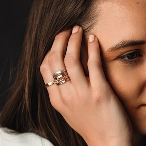 Stackable name ring collection called the maya on a models hand