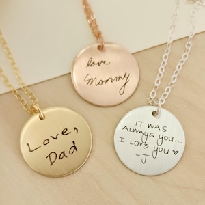 May include: Three pendant necklaces with handwritten inscriptions. One gold-toned pendant reads "Love, Dad", a rose gold pendant says "love mommy", and a silver pendant says "IT WAS ALWAYS you... I love you -J".