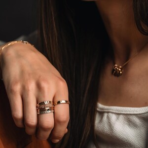 Stackable name ring collection called the maya on a models hand