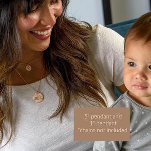 May include: Two rose gold pendants, one .5 inches and one 1 inch, hang on a chain. The larger pendant has engraved text. The image also shows a woman and a baby. The text on the image says ".5" pendant and 1" pendant *chains not included."