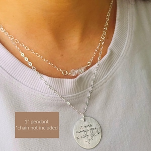 May include: A layered silver necklace with a round pendant. The pendant has the handwritten text "IT WAS ALWAYS you. I LOVE you -J". The necklace has a 1-inch pendant, and the chain is not included.