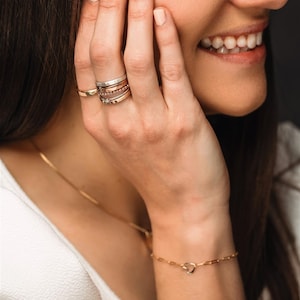 Stackable name ring collection called the maya on a models hand