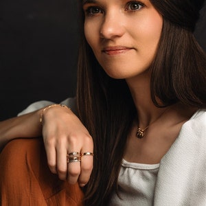 Stackable name ring collection called the maya on a models hand