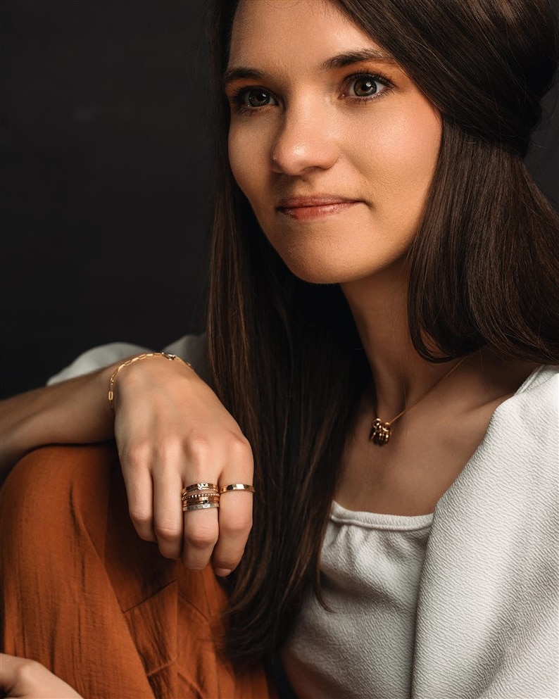 Stackable name ring collection called the maya on a models hand