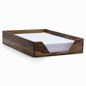 Peut inclure: Un organiseur de bureau en bois avec une finition brun foncé. L'organisateur a une fente pour tenir des papiers et est fait de bois massif.