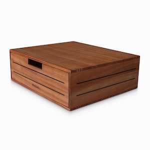 May include: A wooden box with a handle on the top. The box has a dark wood finish and is made of solid wood. The box has a label on the front that says "WOODGALA".
