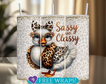 May include: A tumbler featuring a cartoon duck wearing glasses, a bow, and a leopard print scarf. The text "Sassy and Classy" is written in gold script. The background is white with a leopard print pattern. Includes a straw.