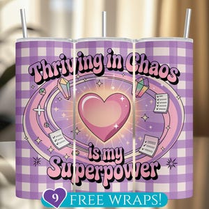 May include: Purple and white checkered tumbler with the text "Thriving in Chaos is my Superpower" in a retro font. A pink heart with sparkles is in the center of the design.