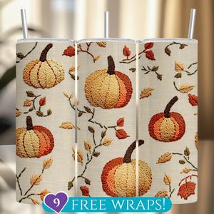 May include: Three stainless steel tumblers with a fall-themed embroidered pumpkin and leaf design. The pumpkins are in shades of orange and yellow, with brown stems. The background is a cream color. The text "9 FREE WRAPS!" is at the bottom.