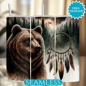 Può includere: Un bicchiere in acciaio inossidabile con un'illustrazione dettagliata di un orso bruno, un acchiappasogni e una scena di foresta sotto la luna piena. Il bicchiere ha una cannuccia e le parole "FREE DESIGNS" e "SEAMLESS".