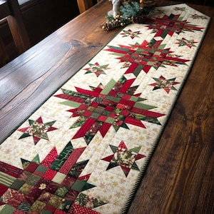 May include: A festive Christmas table runner featuring a starburst design in red, green, and cream. The quilted runner has a repeating star pattern and a green rope border. The runner is placed on a wooden table.