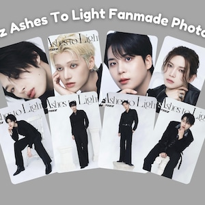 May include: A collection of fanmade photocards featuring members of the K-pop group Ateez. Each card displays a different member with the text "Ashes To Light". The cards have a rectangular shape and are arranged on a gray background.